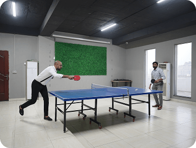 Colleagues playing table tennis in the office